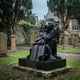 Polished black granite lion over an open book in a churchyard