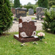 Red granite bear and heart memorial with a pale hammered head, on a cemetery lawn