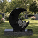 Black granite moon and bear child memorial shown on a cemetery lawn