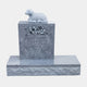 Grey granite headstone with a sleeping lamb on the cap and an engraved flower spray, 110cm