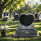Black and grey granite heart headstone shown on a cemetery lawn