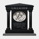 Black granite temple-form memorial with polished columns and a carved white marble roundel, 300cm