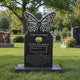The black granite butterfly headstone standing on a mown lawn
