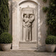 Marble memorial plaque with winged figure shown recessed into an ashlar garden wall