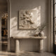 Marble woman and winged infant relief shown wall-mounted above a fluted console
