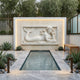 Reclining mermaid cream marble relief shown on a pool house wall