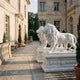 Standing Lion on a Swagged Pedestal Marble Statue, 210cm, white marble lions roaring on a carved pedestal with leaf swags, set on a stone courtyard patio.