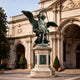 Monumental Classical Archangel Michael Bronze Sculpture by Giant Sculptures, 300cm verdigris figure with raised sword on stone column outside a classical building.