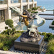 Monumental Contemporary Mermaid with Dolphin and Turtle Bronze Sculpture by Giant Sculptures on a granite plinth beside a reflecting pool overlooking the sea.