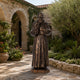 Monumental Traditional Robed Friar Bronze Statue, 300cm, in a courtyard with stone arches and greenery, hands raised in blessing with a rosary.