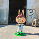 The Giant Sculptures World Cup No.10 Dribble Labubu Sculpture (100cm) features a cartoonish figure with bunny ears in an Argentina #10 soccer jersey, standing on green turf beside a soccer ball, set before an industrial building marked with a spray-painted 3.