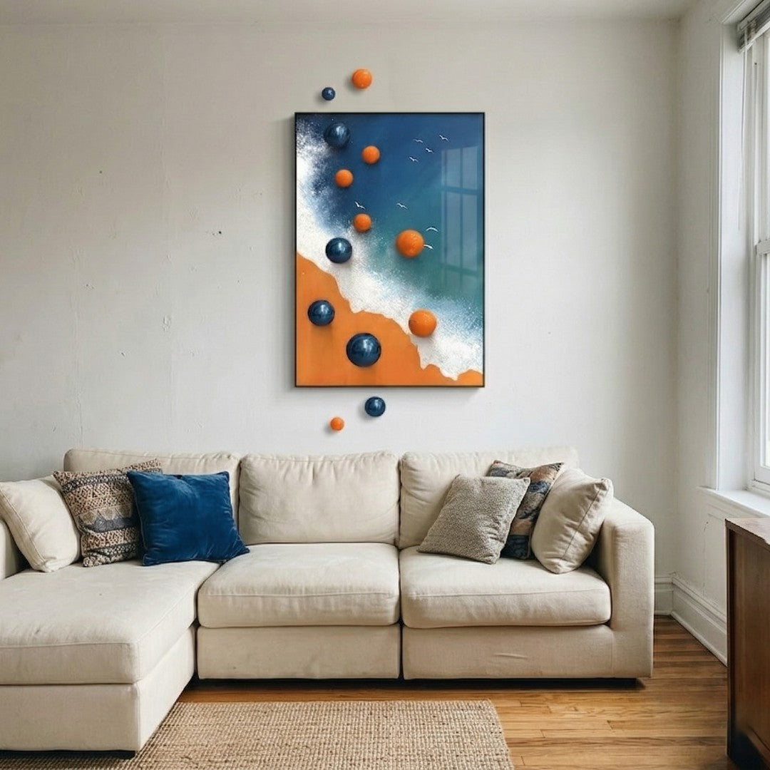 Tideborne Blue & Orange Coastal 3D Wall Art With Metal Balls by Giant Sculptures displayed above a cream sectional sofa, featuring glossy blue and orange metal spheres extending beyond an aluminium-framed canvas depicting a shoreline scene.