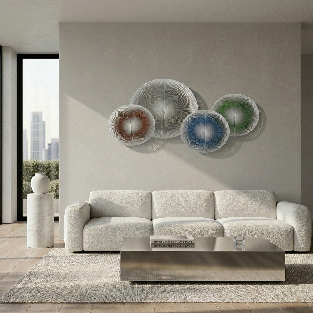 Centria Multicolour Disc 4-Panel 3D Leather Wall Art by Giant Sculptures mounted above a white bouclé sofa in a modern living room, showing overlapping radial discs in silver-grey, burnt orange, blue, and green.