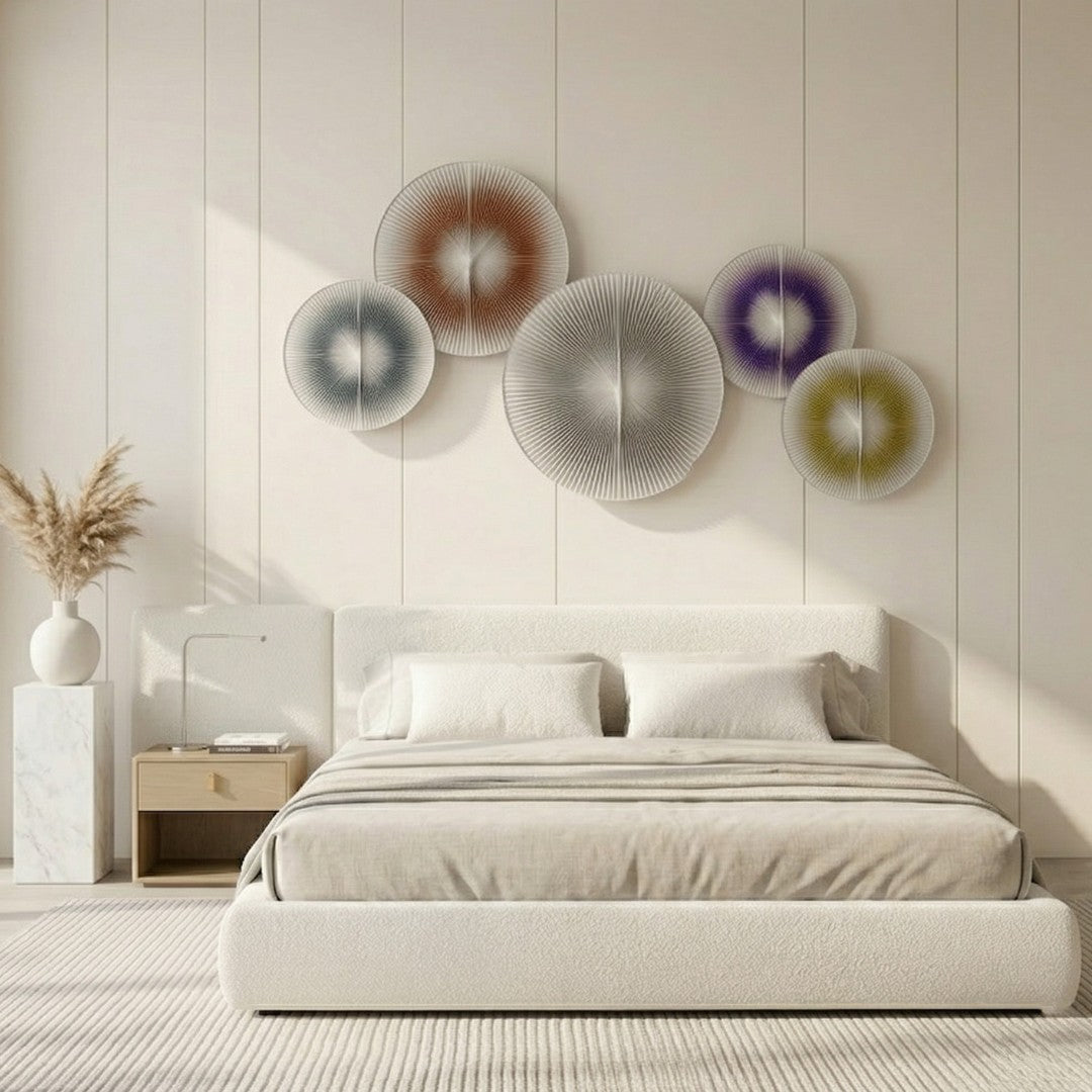 Centria III Multicolour Disc 5-Panel 3D Leather Wall Art by Giant Sculptures displayed above a cream upholstered bed, featuring blue, terracotta, grey, violet, and olive radial-fold discs on a panelled white wall.
