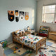 Vinylora Sunset & Space Vinyl Records 5-Panel Wall Art by Giant Sculptures displayed above a toddler bed, showing vinyl records paired with sunset and astronaut canvas prints on a light blue wall.