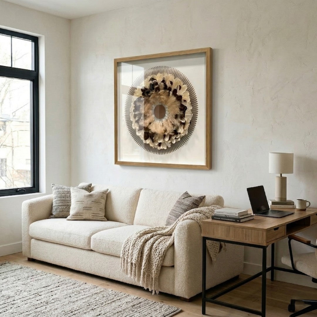 Quillara Cream & Mocha Feather Halo 3D Wall Art by Giant Sculptures mounted above a cream bouclé sofa in a neutral living room with wood desk and textured rug.