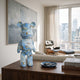 Ocean Spray Bear Sculpture - 50cm in blue and gold swirled resin with kintsugi-style veining, displayed on a wood sideboard in a living room with city views.