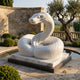 Coiled Snake White Marble Statue - 150cm, raised S-curve head with scale detailing, on a marble slab and dark base beside a garden pool.