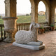 Couchant Sheep White Marble Statue - 70cm by Giant Sculptures, carved with curled fleece on a rectangular base, displayed on a stone terrace overlooking vineyards.