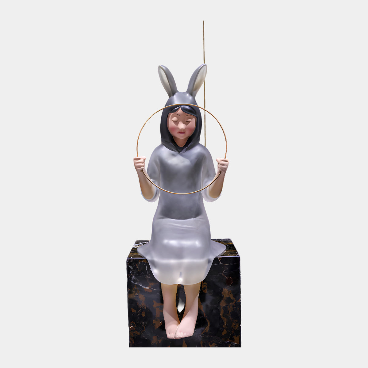 Frosted Lilac Hooded Seated Figure Resin Sculpture, 84cm, shown seated on a black marble block with rabbit-eared hood, holding a gold metal hoop, on a plain white background.
