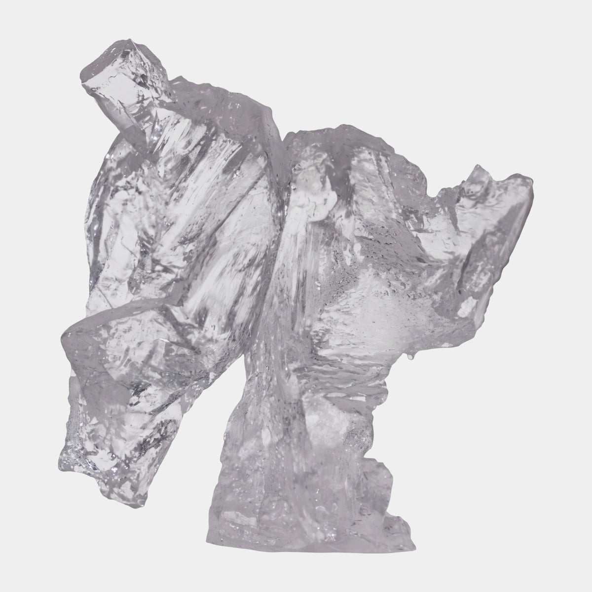Clear Forward-Leaning Torso Cast Resin Sculpture (26cm) by Giant Sculptures, faceted colorless resin form with arms hewn into the flanks, shown on a plain white background.