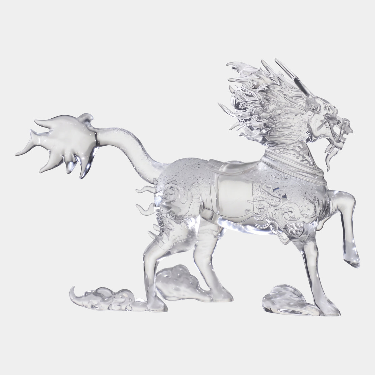 Clear Horned Beast on Carved Cloud Scrolls, 32cm resin sculpture with a horse body, dragon head, spiked mane and flared tail, each foot on a carved cloud scroll, on a plain white background.