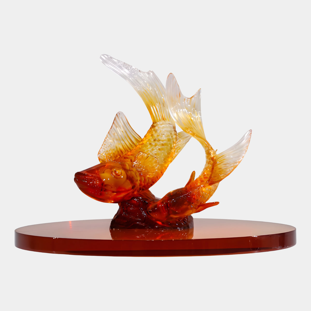 Amber Leaping Carp Pair on a Base - 55cm, resin sculpture of two carp leaping over a rock with amber-red to clear fins, on a round dark red lacquered acrylic base, plain white background.