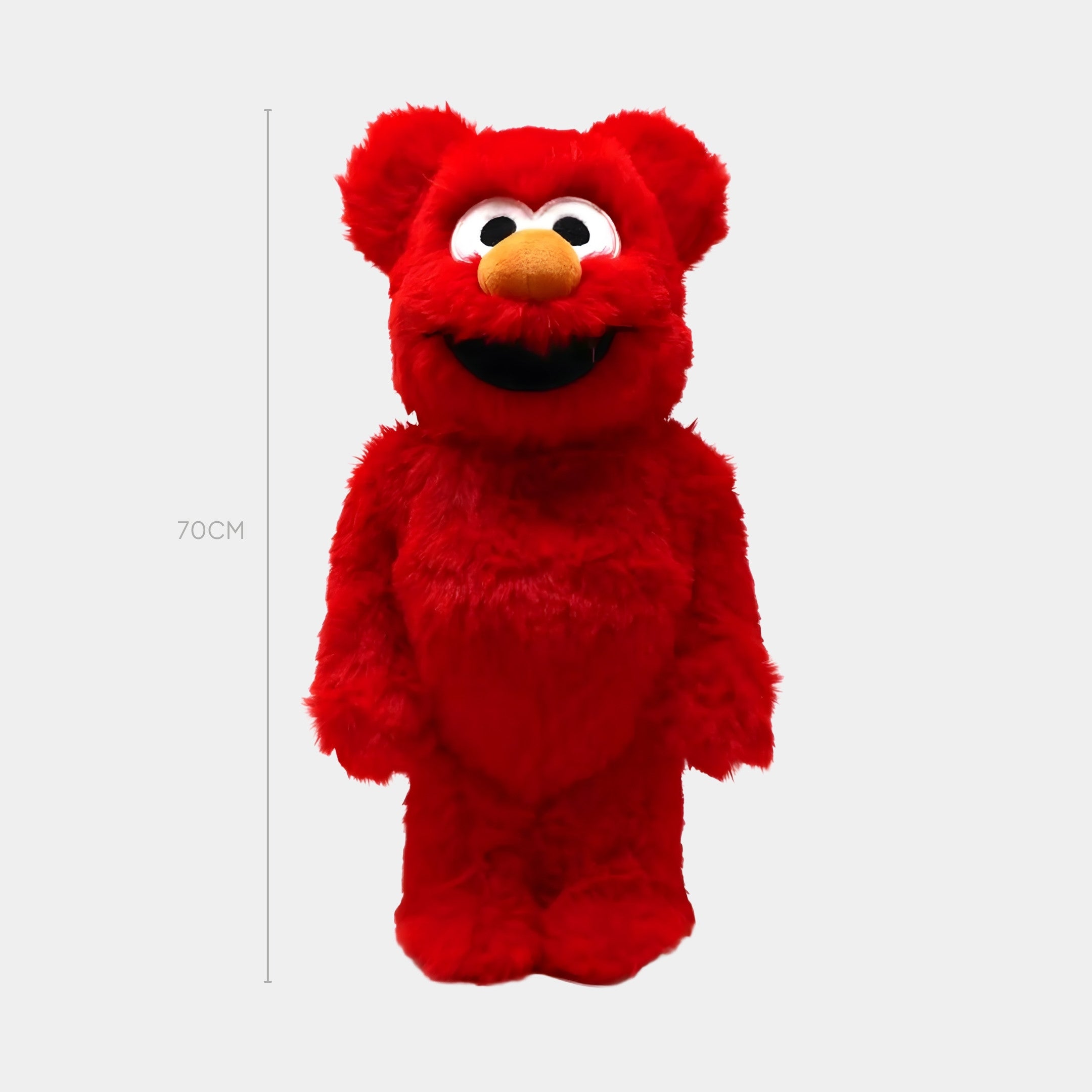 A person stands next to the Red Fuzzy Bear Sculpture - 70cm by Giant Sculptures, a bright red, plush character with large white eyes, an orange nose, and an open mouth. The sculptures height is marked as 70 cm.