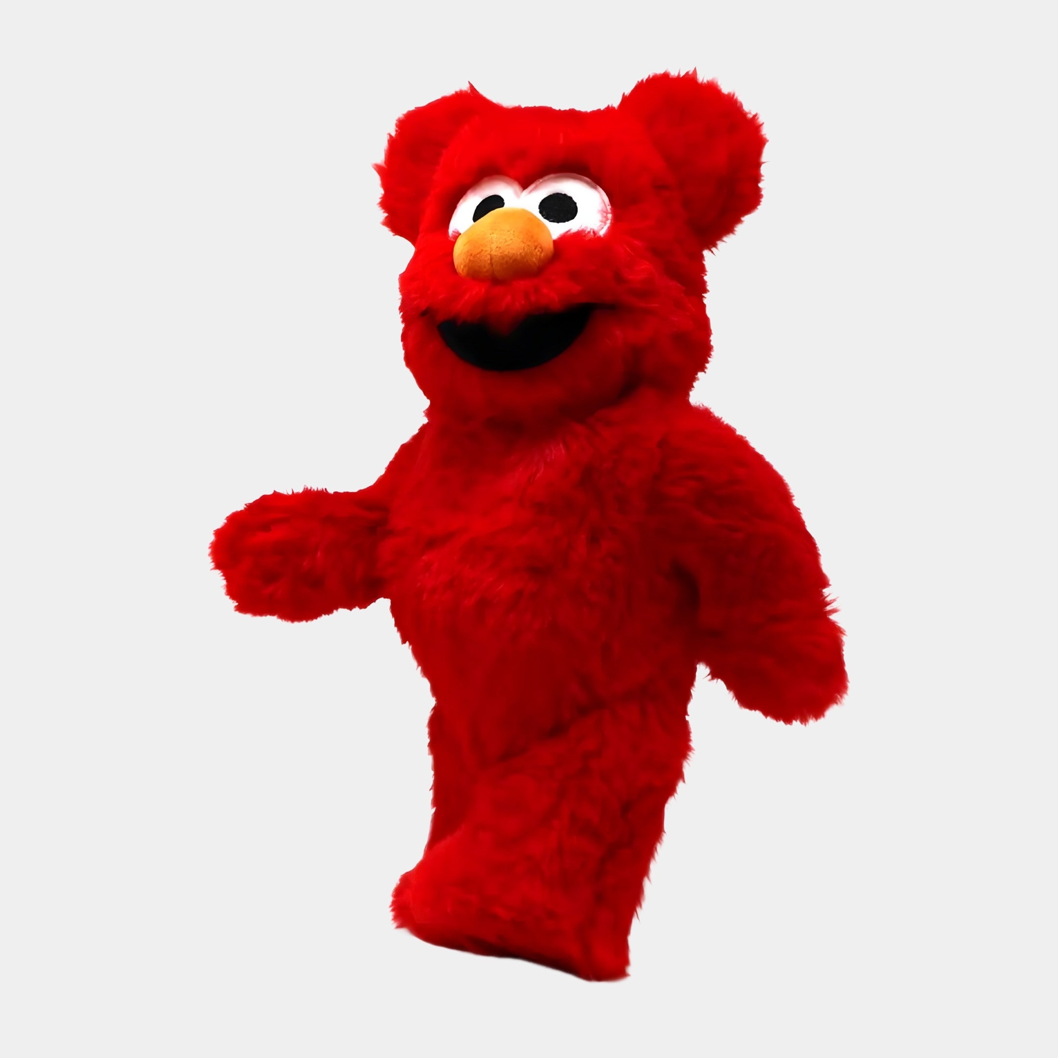 A person in a bright red, plush fur Elmo costume with white eyes and an orange nose stands facing left, resembling the Giant Sculptures Red Fuzzy Bear Sculpture - 70cm against a plain white background.