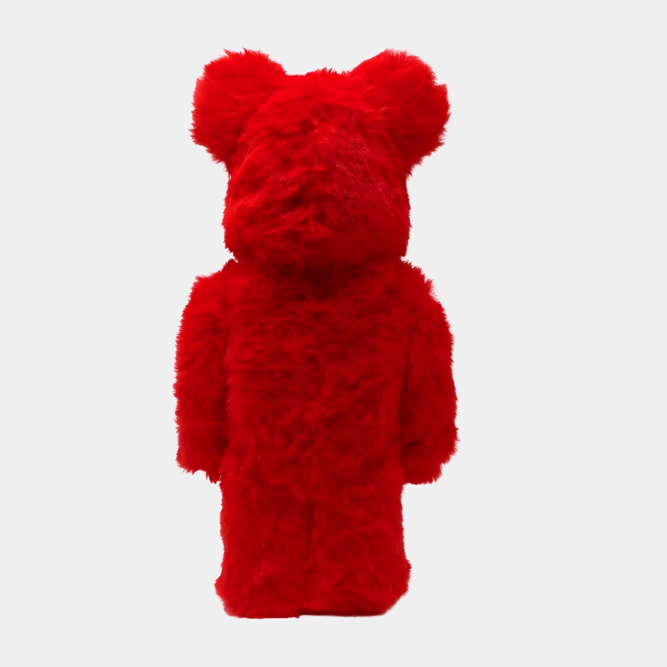 The Red Fuzzy Bear Sculpture - 70cm by Giant Sculptures stands upright and faces away, featuring plush red fur, round prominent ears, and no visible facial features on a plain white background.