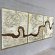 Riverine Flow Pearl White Textured Triptych Wall Art by Giant Sculptures, three gold-framed panels with sculpted white texture over a bronze flowing river motif, mounted on a light grey wall.