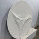 Selene V White Sandstone Textured 3D Wood Relief Wall Art, round panel with eroded cliff-like texture, leaning against a grey wall on a stone plinth.