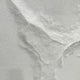 Close-up of the Selene V White Sandstone Textured 3D Wood Relief Wall Art showing its rough, eroded white-stone surface with deep cracked ridges.