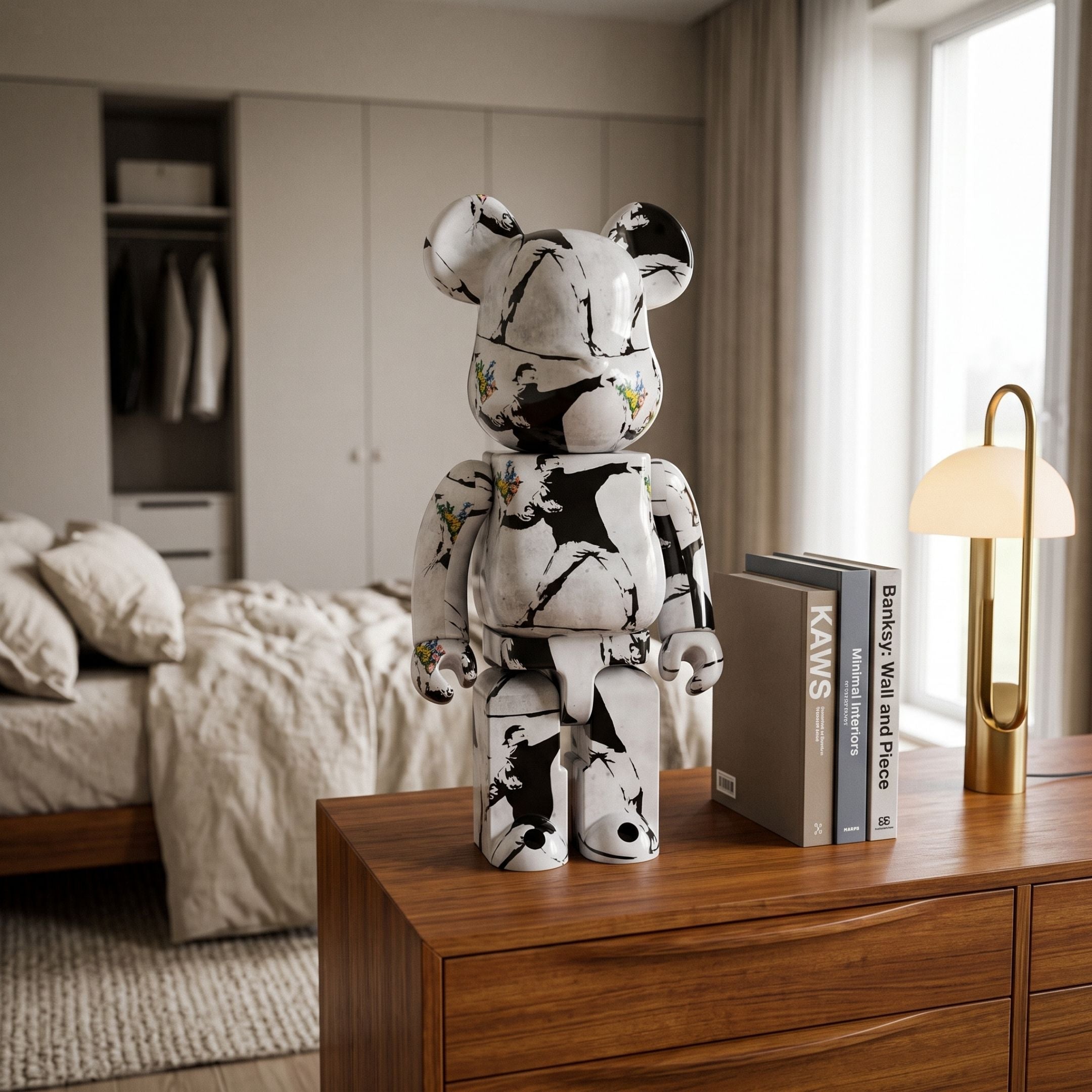 Stencil Art Bear Sculpture (70cm) in black-and-white graffiti-style resin finish, displayed on a wooden dresser in a bedroom beside books and a brass lamp.