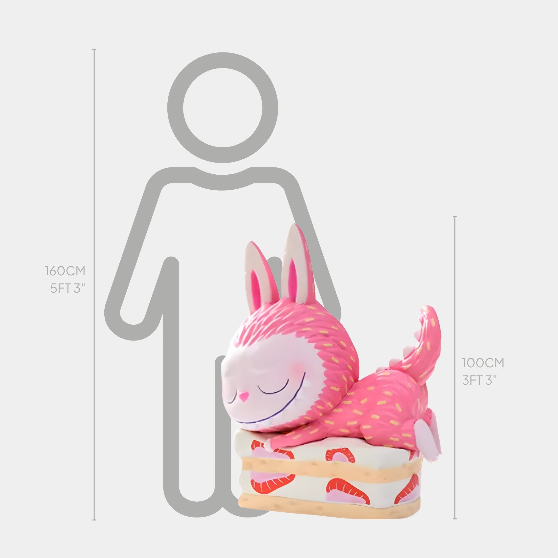 A pink, smiling fantasy creature with bunny ears sits on a sandwich, standing 100cm tall beside a 160cm person. The Giant Sculptures Sweet Mischief Strawberry Cake Labubu Sculpture makes a whimsical indoor statement for themed interiors.