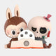 The Giant Sculptures Spooky Buddies Blade Trick Labubu Sculpture (160cm) features a brown bunny and a skeleton in a pink hat reading together. The skeleton holds a red pen and has a blue teardrop, evoking dark comedy display vibes.