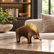 Small Modern Abstract Bull Bronze Sculpture by Giant Sculptures with warm golden patina, displayed on a travertine coffee table beside books, a bowl, and linen sofa.