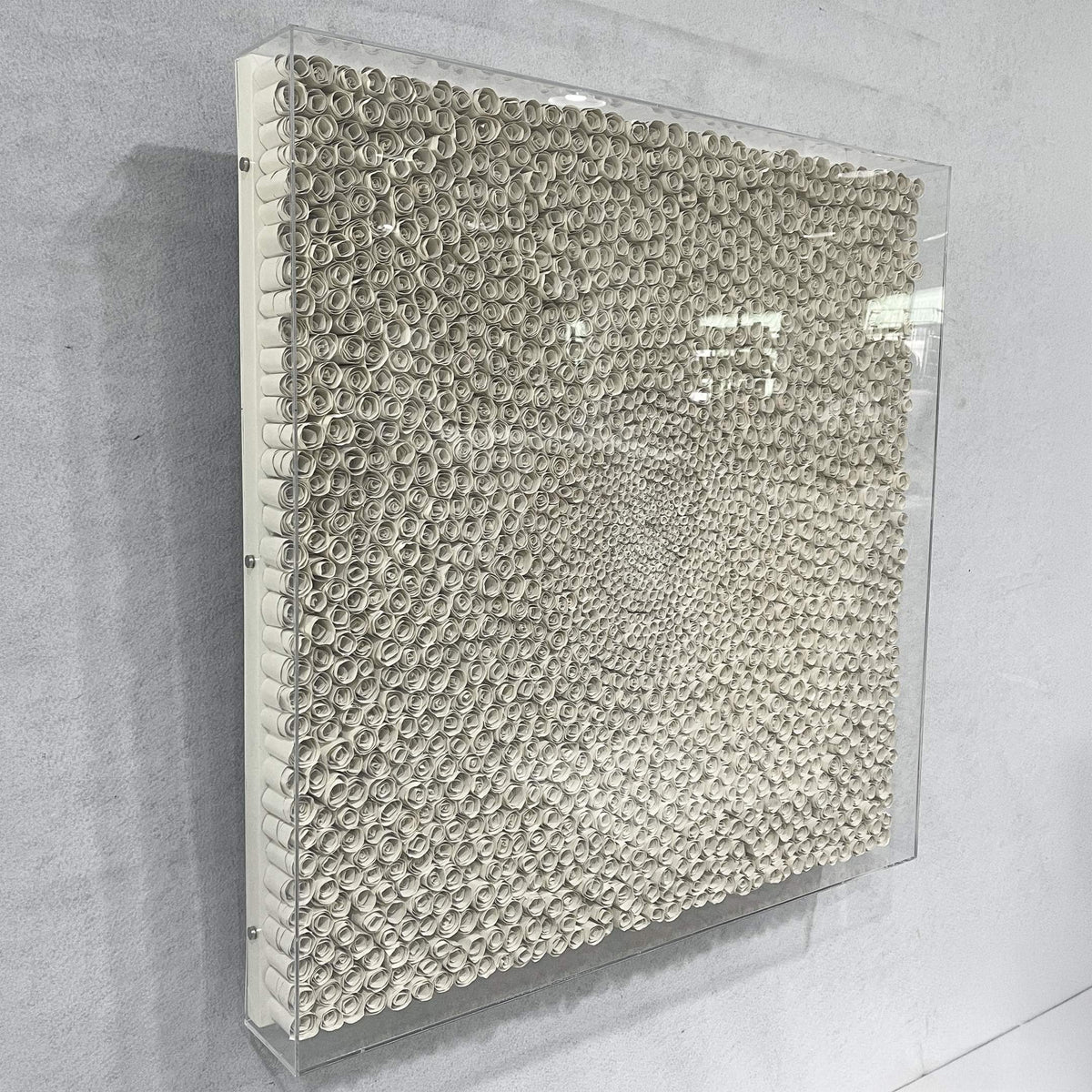 TerraLuma Ivory White Bloom Paper Craft 3D Wall Art, side angle view showing hand-coiled paper rosettes in a radiating pattern, framed in acrylic on a light grey wall.
