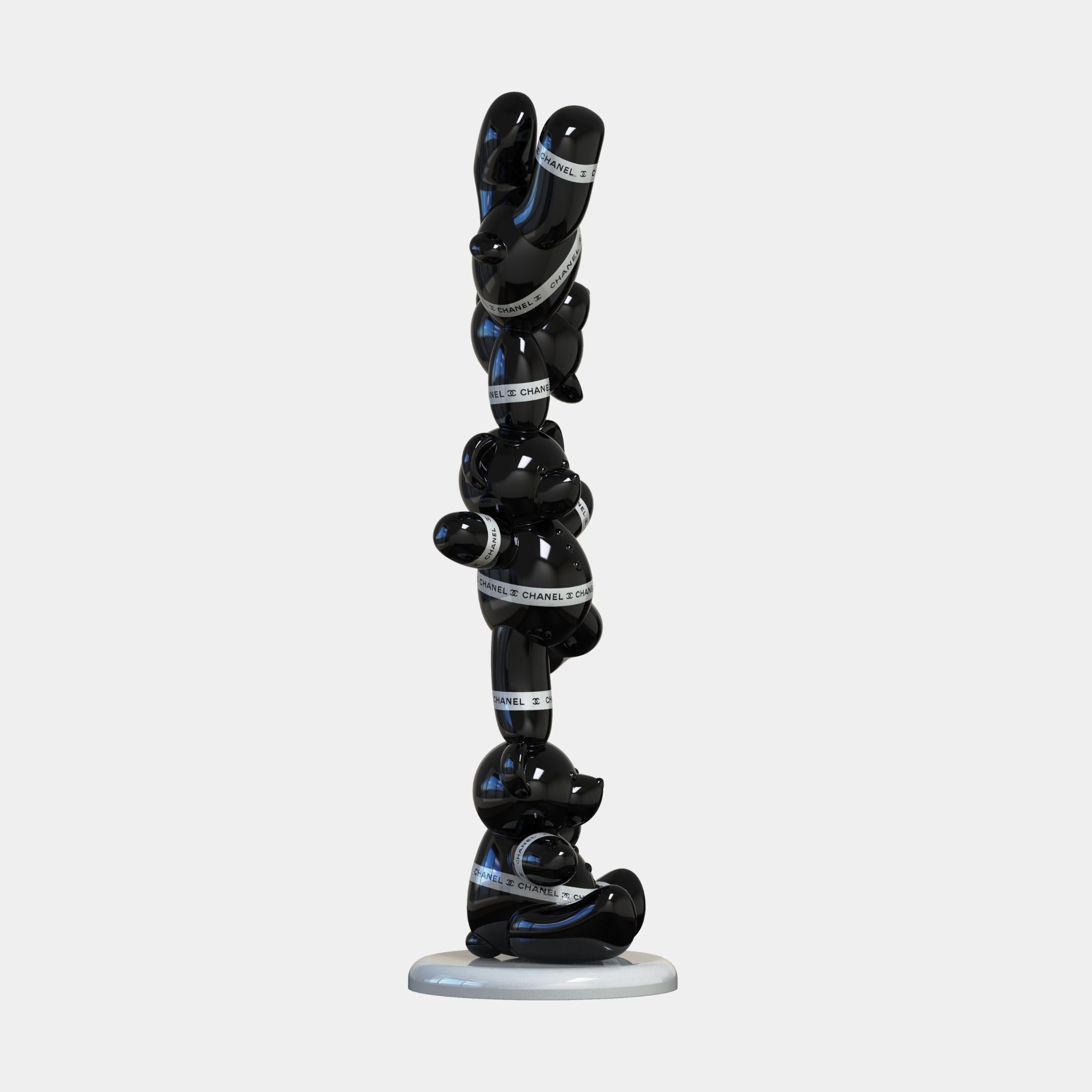 The Gacko Black Chanel Triple Bear Sculpture (90cm) by Giant Sculptures features intertwined, glossy black forms with a BLUE CHANNEL STUDIOS band on a round white base—a bold piece of contemporary art decor against a white backdrop.