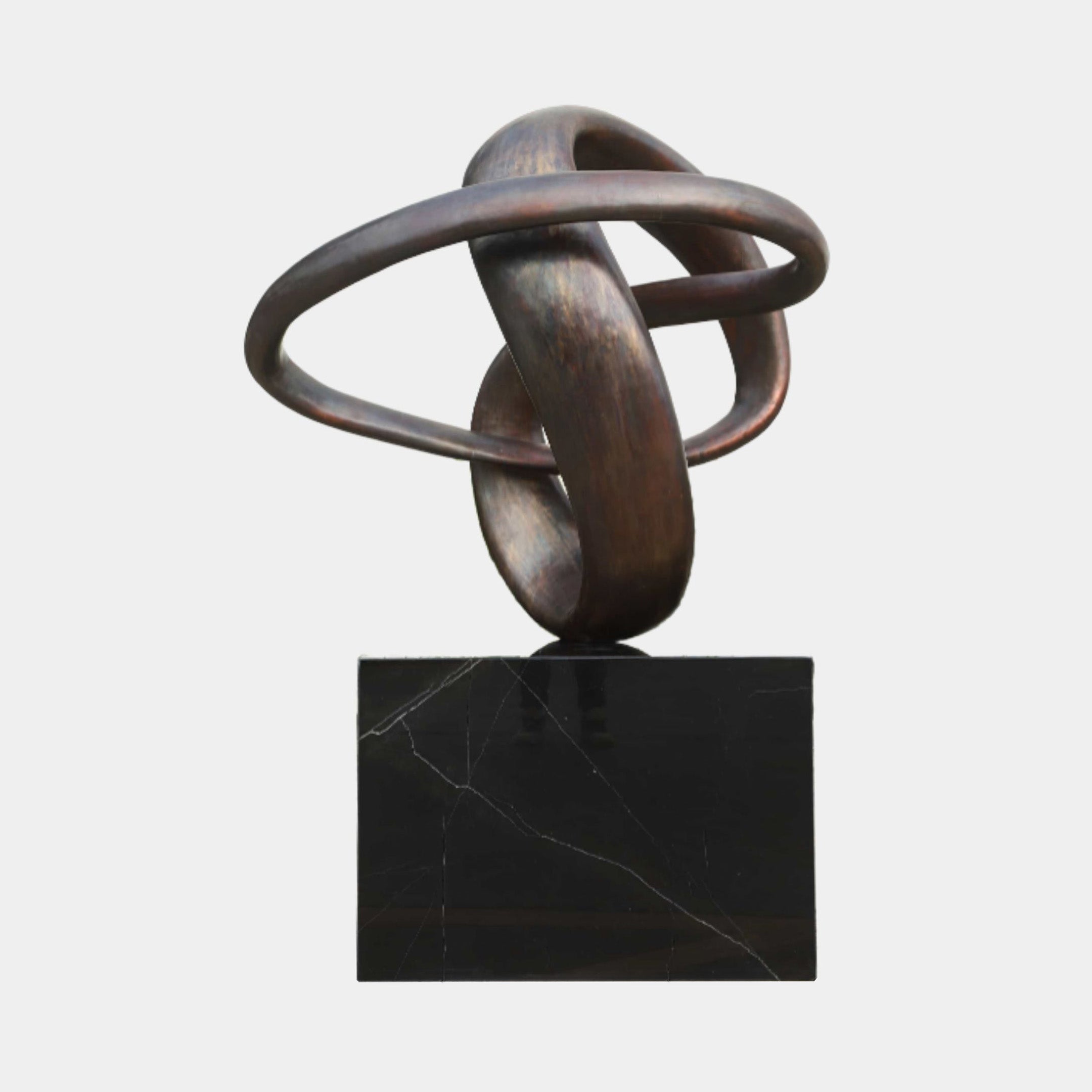 Bronze Interlocking Rings Metal Sculpture by Giant Sculptures, 131cm, two tilted rings with dark patina on a black marble base against a plain background.