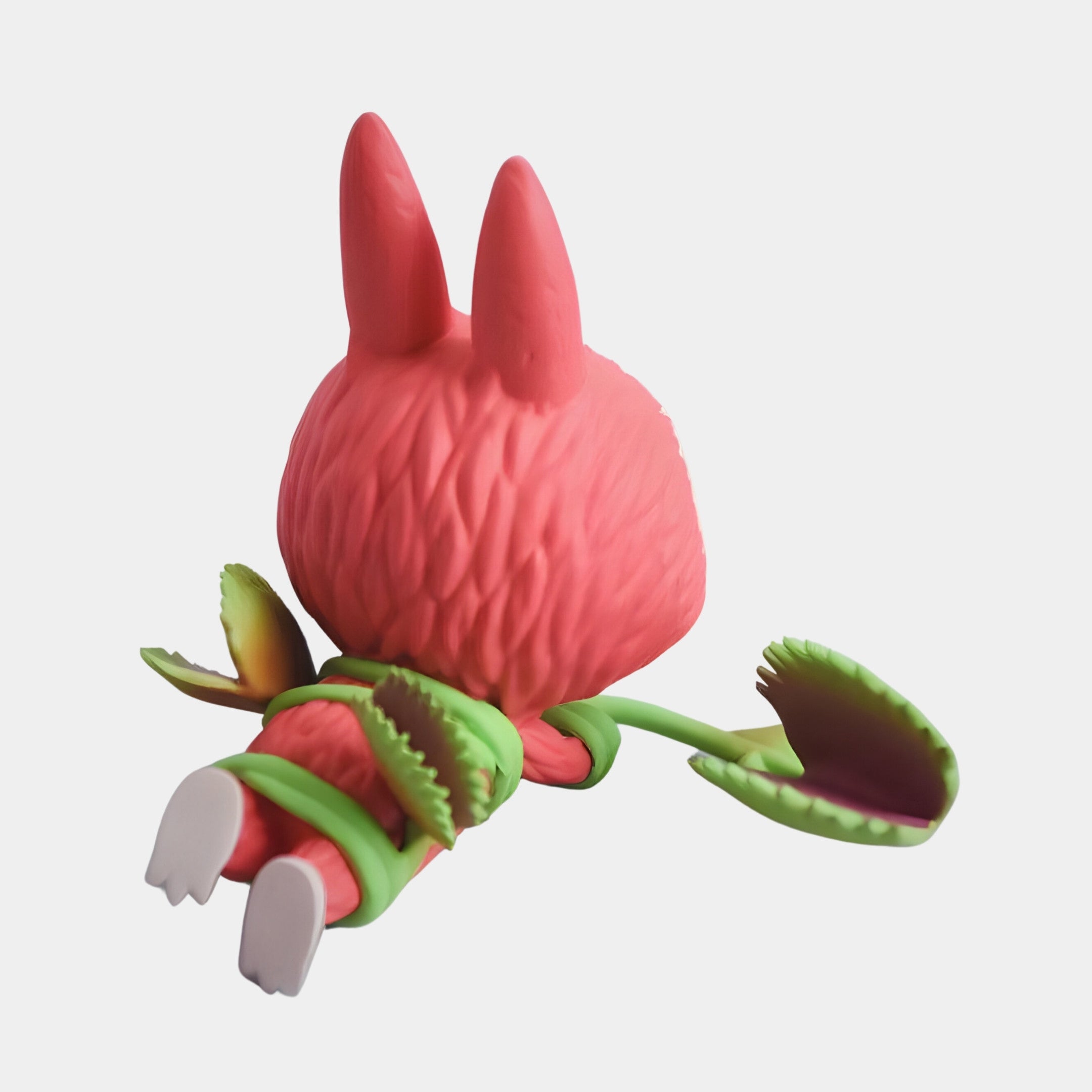 The Giant Sculptures Flower Elves Venus Flytrap Labubu Sculpture - 160cm features a pink, furry Labubu with rabbit-like ears lying face down, entwined by two green Venus Flytrap stems on a plain white background.