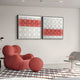 A modern room shines with a bold red abstract chair and matching round ottoman on a geometric rug. Two Giant Sculptures Tessera White & Coral II Geometric Wood 3D Wall Art pieces hang above, in red, white, and gray tones. A minimal gray chair and small side table finish this artistic setup.