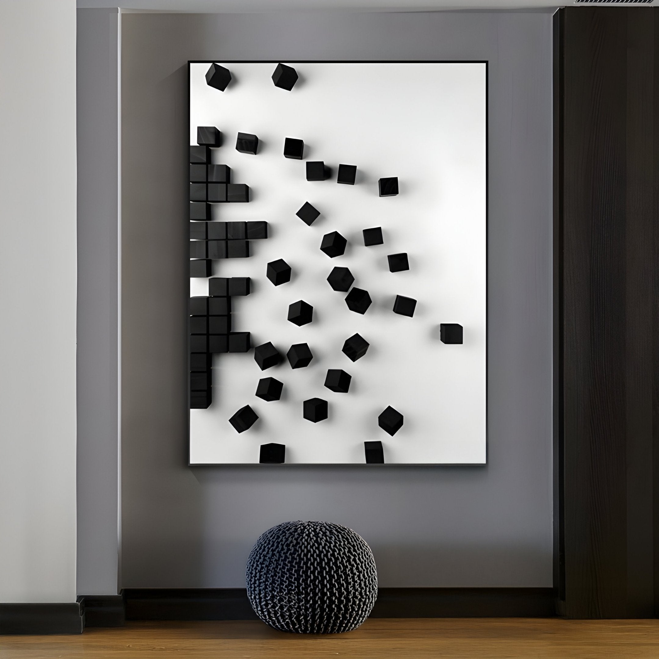 The Fragmenta White Wooden Cube Scatter on White Canvas 3D Wall Art by Giant Sculptures features a modern design with black cubes on a white background. It creates a striking 3D effect, complemented by a dark, textured pouf resting on the wooden floor.