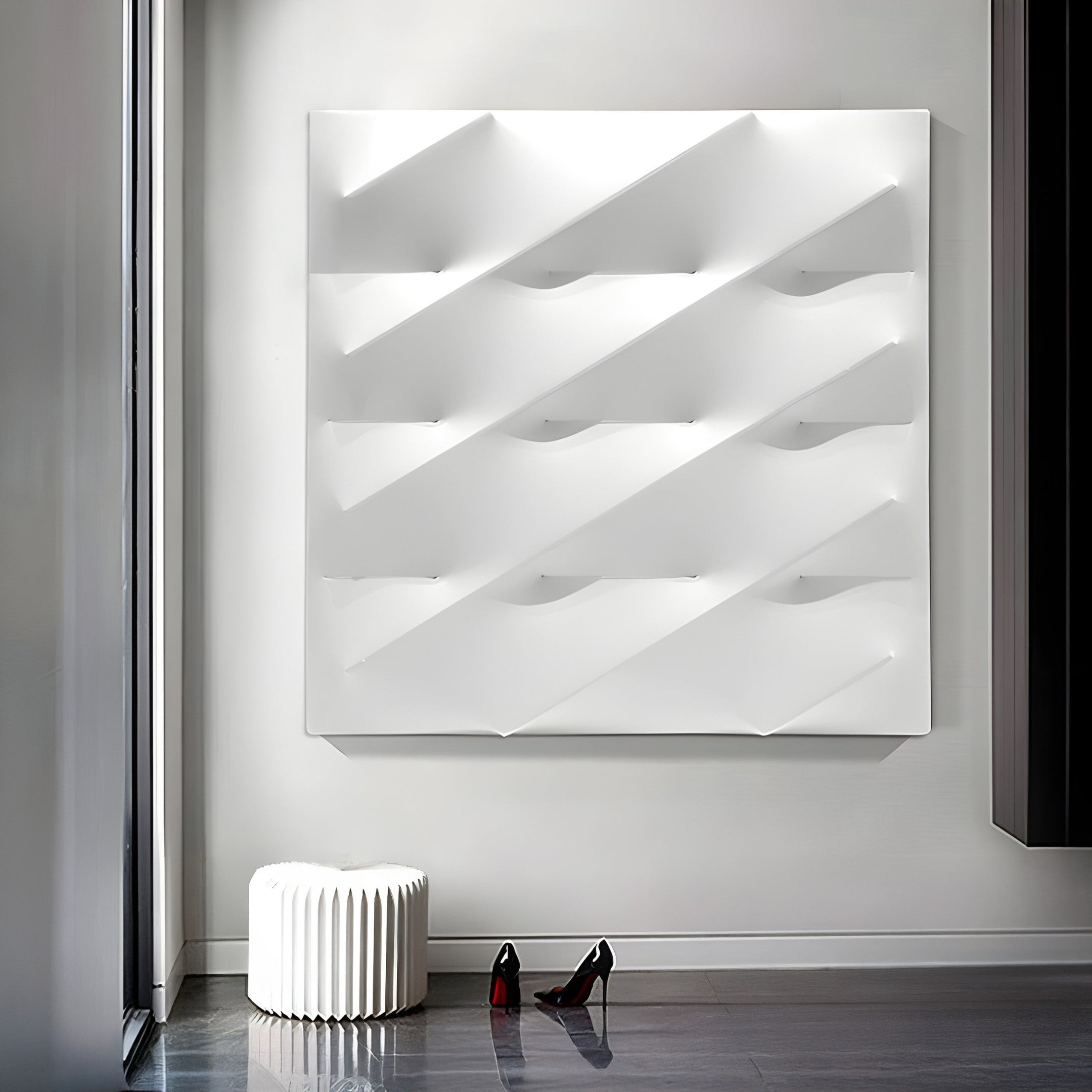 The space is adorned with Giant Sculptures Verto White Stretch Fabric Layered Wooden 3D Wall Art, its geometric design enhancing the rooms style. Below, black high-heeled shoes and a white ribbed stool sit on a glossy floor. Natural light filters softly through large windows to the left.