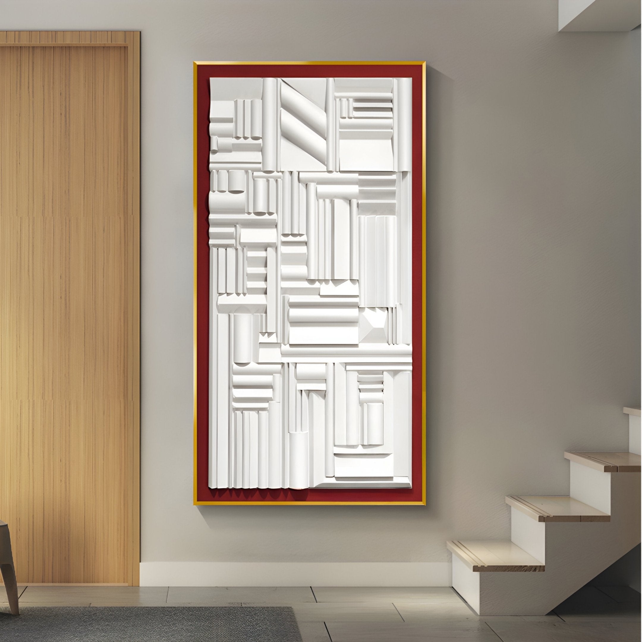 The Forma Red-Frame White Geometric 3D Wooden Vertical Wall Art by Giant Sculptures elegantly hangs with bold shapes in white, accentuated by a striking gold and red-frame border, set against a wooden door and staircase featuring pristine white steps to the right.