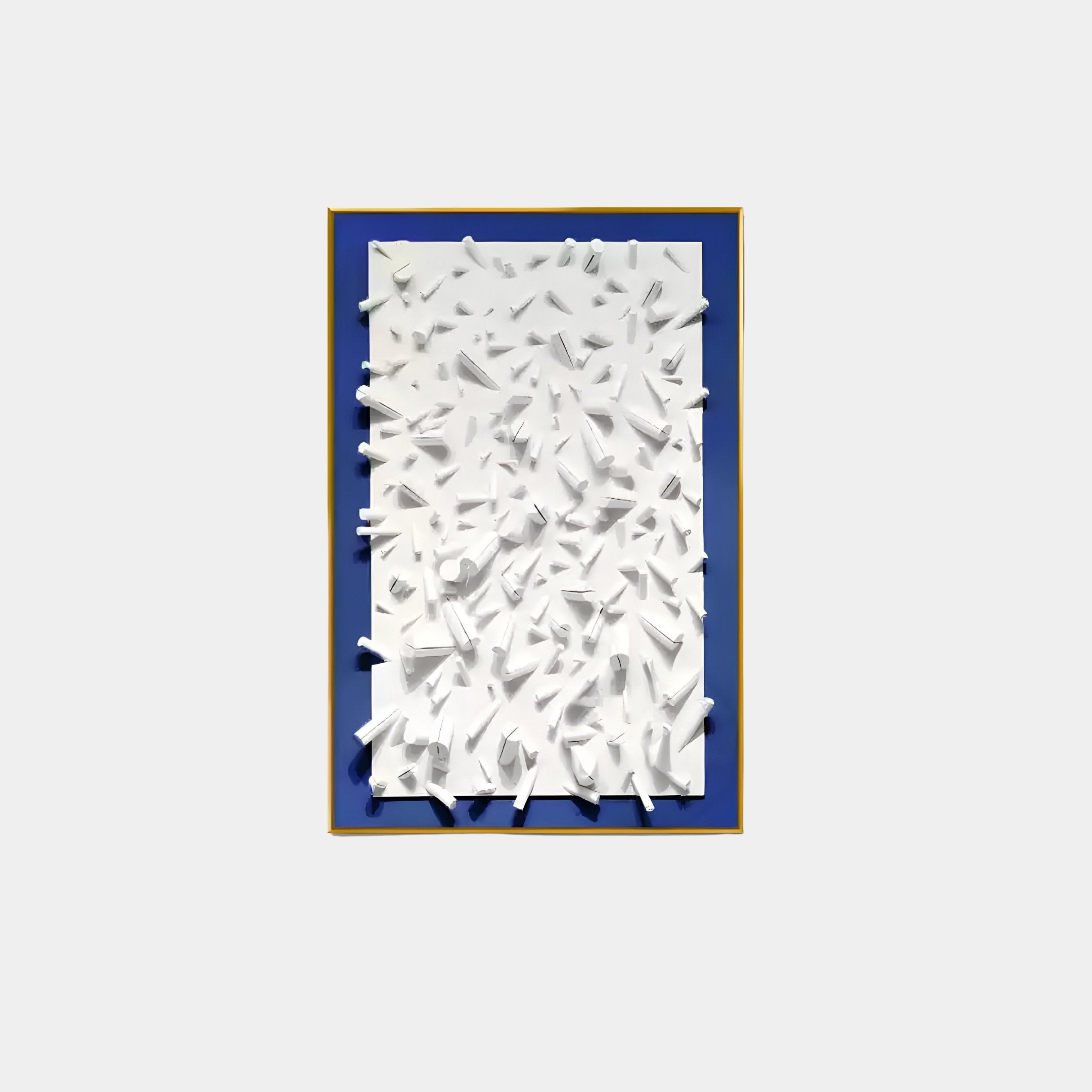 The Artiora Blue Edge & White Abstract Wooden Shard 3D Wall Art by Giant Sculptures features white, paper-like three-dimensional shapes from a blue backdrop framed in yellow, creating a textured, dynamic effect.