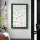 A modern interior features Giant Sculptures Artiora Green Edge & White Abstract Wooden Shard 3D Wall Art, showcasing textured white abstract shapes on green. Nearby, a small plant and a shelf with a white owl sculpture add depth and detail along the rooms green edge.