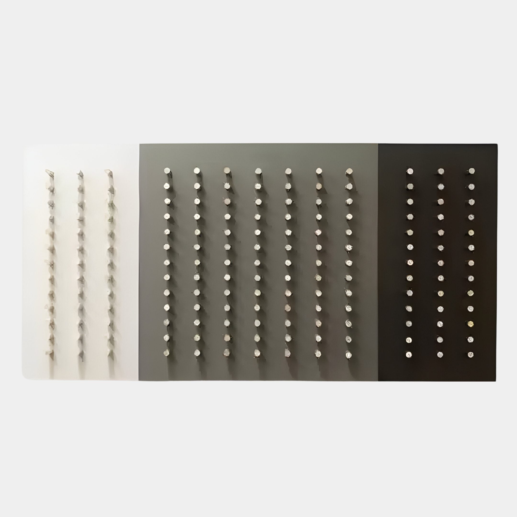 The Contrasto Monochrome Symmetry 3D Wooden Wall Art by Giant Sculptures features three vertical panels in light to dark gray, each with rows of white pegs, creating a striking example of Minimalism and modern geometry.