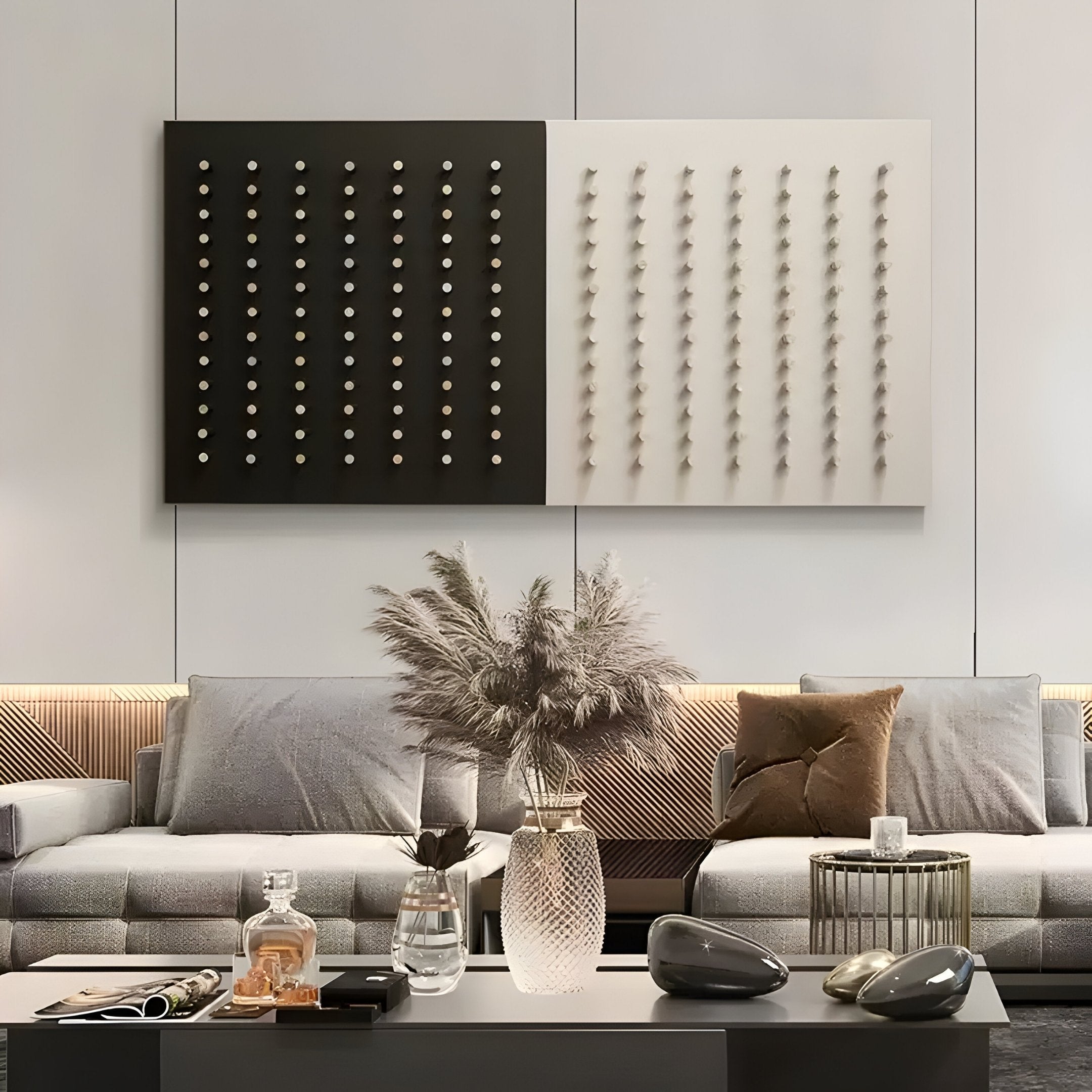 In a modern living room, a gray sofa is adorned with brown and gray cushions, accompanied by a low table holding decorative items and glasses. The wall features Contrasto Dual-Tone Geometric 3D Wooden Wall Art by Giant Sculptures. Pampas grass in a vase adds a natural touch.