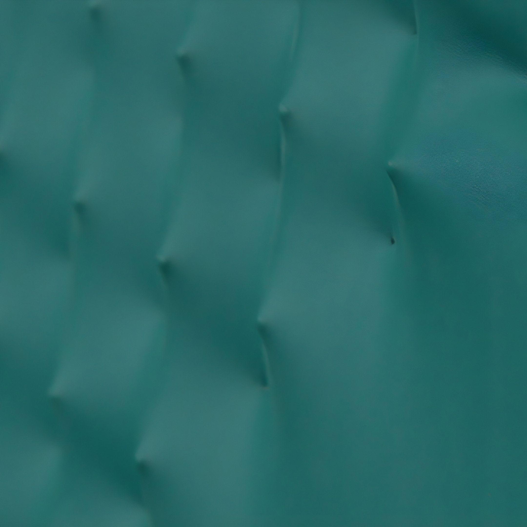 Close-up of Giant Sculptures Illustra Teal Highlight BOOM Text 3D Wooden Wall Art, showcasing a teal surface with a textured, wavy pattern. Raised bumps align diagonally to cast gentle shadows, enhancing the geometric design reminiscent of wall art.